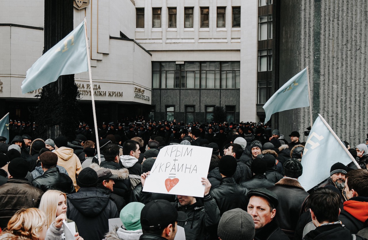 Getty Images / «Бабель» | Проукраїнський мітинг активістів із кримськотатарськими прапорами перед парламентом у Сімферополі незадовго до окупації Криму росією, 26 лютого 2014 року.